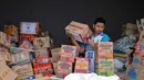 Di antaranya, 13,5 ton bantuan akan dialokasikan untuk korban di Medan, Sumatera Utara, sementara 13 ton lainnya dikirim ke Aceh. Tampak dalam foto, seorang relawan mengemas perbekalan untuk dikirimkan ke daerah-daerah terdampak banjir di Badan Penanggulangan Bencana Daerah (BPBD) Sidoarjo, Provinsi Jawa Timur, pada Jumat 5 Desember 2025. (JUNI KRISWANTO/AFP)