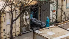 Pekerja memindahkan jenazah dari truk ke kontainer berpendingin di Rumah Sakit Umum Fu Shan, Hong Kong, Rabu (16/3/2022). Kasus COVID-19 terburuk yang melanda Hong Kong menimbulkan kepanikan serta membuat rumah sakit dan kamar jenazah penuh. (DALE DE LA REY/AFP)