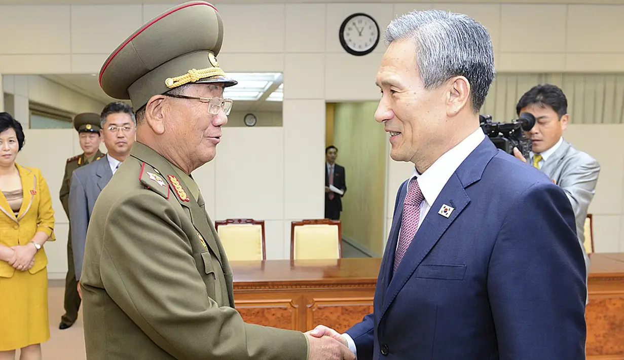 Kepala Keamanan Nasional Korsel, Kim Kwan-jin (kanan) berjabat tangan dengan ajudan militer Korut, Hwang Pyong usai melakukan pertemuan terkait penanaman ranjau darat di Zona Demiliterisasi, di Istana Presiden Korsel, Selasa (25/8/2015). (REUTERS/Yonhap)