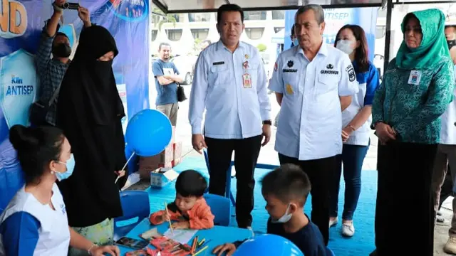 Gubernur Riau Syamsuar melihat anak-anak bermain di lokasi imunisasi.