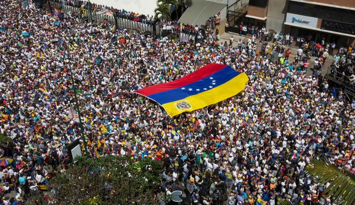 Puluhan ribu demonstran antipemerintah menuntut pengunduran diri Presiden Venezuela Nicolas Maduro di Caracas, Venezuela, Sabtu (2/2). Tokoh oposisi Juan Guaido mendeklarasikan dirinya sebagai 'presiden interim'. (AP Photo/Juan Carlos Hernandez)