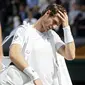 Andy Murray memegang hanya tertunduk saat keluar dari arena usai kalah dari Sam Querrey pada laga tunggal putra Wimbledon Tennis Championships 2017 di London, (12/7/2017). (AP/Kirsty Wigglesworth)
