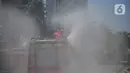 Petugas Dinas Pemadam Kebakaran Pemprov DKI melakukan penyemprotan cairan disinfektan di Jalan Thamrin, Jakarta, Selasa (31/3/2020). Penyemprotan yang dilakukan terus menerus itu untuk meminimalisir penyebaran COVID-19 di ruang udara dan ruas jalan. (Liputan6.com/Faizal Fanani)