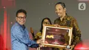Pemimpin Redaksi Liputan6.com, Titis Widyatmoko (kanan) saat menerima penghargaan dari Otoritas Jasa Keuangan (OJK) untuk Kategori Media Online Terproduktif SubKategori Media Umum pada acara OJK Apresiasi Media Massa, Jakarta, Selasa (2/12/2025). (Liputan6.com/Helmi Fithriansyah)