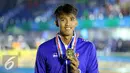 Perenang Jawa Barat, Triadi Fauzi S memamerkan medali kelas 100m gaya bebas putra di Gelanggang Renang FPOK UPI, Bandung, Senin (19/9). Triadi berhasil meraih emas sekaligus memecahkan rekor PON dengan 50,49 dtk. (Liputan6.com/Helmi Fithriansyah)
