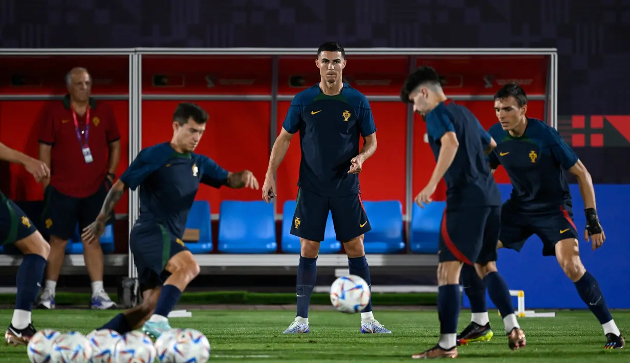 Penyerang Portugal, Cristiano Ronaldo (Tengah) dan rekan setimnya mengikuti sesi latihan di lokasi latihan Al Shahaniya SC, barat laut Doha pada 5 Desember 2022. Portugal akan menghadapi Swiss pada babak 16 besar Piala Dunia 2022 Qatar di Stadion Lusail Iconic, Rabu (7/12) dini hari WIB. (AFP/Patricia De Melo Moreira)