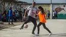 Mantan pemain bola Juventus, David Trezeguet bersiap menendang bola saat bermain bersama anak-anak di komunitas San Pablo Mirador, Peru (13/7). (AFP Photo/Ernesto Benavides)