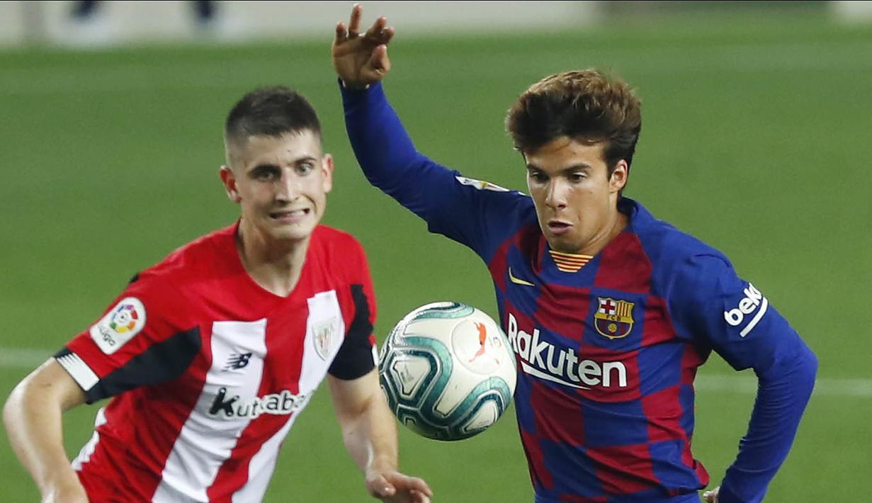 Pemain Barcelona, Riqui Puig, berebut bola dengan pemain Athletic Bilbao, Oihan Sancet, pada laga La Liga di Stadion Camp Nou, Selasa (23/6/2020). Barcelona menang 1-0 atas Athletic Bilbao. (AP/Joan Monfort)