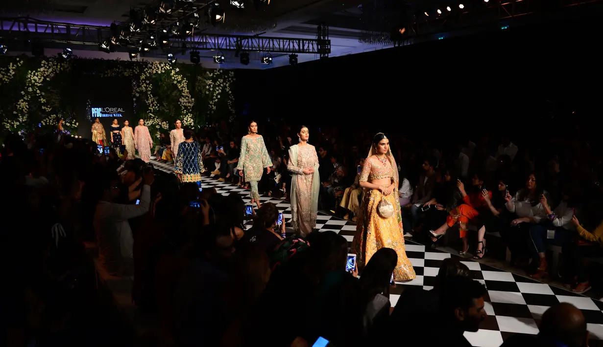 Para model berjalan di atas catwalk mengenakan pakaian tradisional Pakistan rancangan Rema dan Shehrbano selama peragaan busana yang digelar oleh Loreal Paris Pakistan Fashion Design Council di Lahore, Selasa (4/9). (AP Photo / K.M Chaudary)