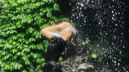 Tak hanya cukup memandangi keindahannya, Natalie Zenn menikmati aliran air terjun yang menghujaninya. Momen ini sukses jadi healing pemeran sinetron "Dewi Rindu" ini. (Liputan6.com/IG/@nataliezenn24).