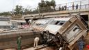 Aparat kepolisian berdiri dekat sebuah kereta api yang terguling di Sidi Bouknadel, Maroko, Selasa (16/10). Kereta yang dalam perjalanan dari Rabat menuju Kenitra telah keluar jalur di sekitar 20 km dekat Sidi Bouknadel. (AP/Abdeljalil Bounhar)