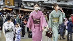 Pengunjung berjalan di sepanjang tujuan wisata di Kyoto, Jepang barat, Senin (13/3/2023). Taman hiburan di Jepang seperti Tokyo Disneyland, Kereta Api Jepang dan operator bioskop Toho termasuk di antara perusahaan besar yang mengizinkan pelanggan untuk tidak menggunakan masker mulai Senin. (Kyodo News via AP)