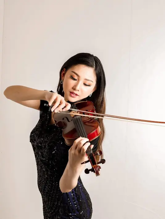 Audrey Vanessa pamer kemampuannya memainkan biola dalam balutan dress cantik. Ia memilih mengenakan sabrina dress dengan warna biru hitam yang memiliki detail embroidery. Memberikan kesan mewah dengan cara yang effortless. [instagram/audreyyvanessa]
