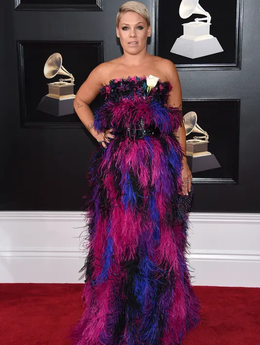 Pink memukau dengan tatanan rambut cepak nan chic di karpet merah Grammy Awards 2018, New York, Minggu (28/1). Namun Pink terlihat seperti 'kemoceng' lantaran penggunaan busana penuh bulu-bulu berwarna ungu, pink, dan biru. (Evan Agostini/Invision/AP)