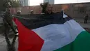 Seorang wanita membentangkan bendera Palestina saat unjuk rasa memprotes kebijakan Presiden AS, Donald Trump soal Yerusalem sebagai ibu kota Israel di luar Kedubes AS di Santiago, Chile, (11/12). (AP Photo / Luis Hidalgo)