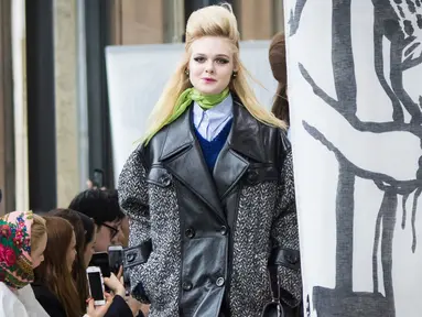 Aktris Elle Fanning memperagakan busana karya Miu Miu pada pagelaran Paris Fashion Week Fall-Winter 2018, Selasa (6/3). Adik dari Dakota Fanning ini memakai coat abu-abu berbahan kulit dengan cutting besar. (Vianney Le Caer/Invision/AP)