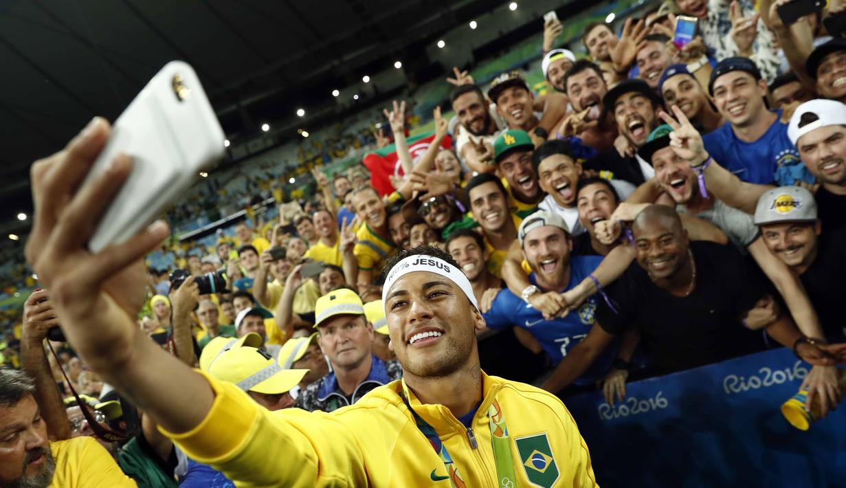 Neymar melakukan foto wefi bersama fans Brasil usai meraih medali emas pada final sepak bola melawan Jerman di Stadion Maracana, Rio de Janeiro, (21/8/2016) dini hari WIB. (AFP/Odd Andersen)