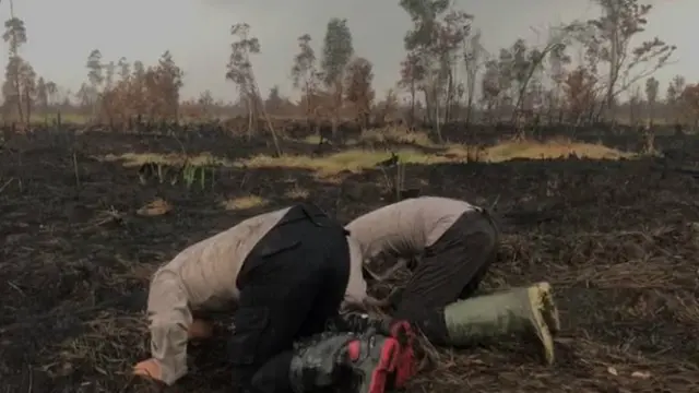 Polisi anggota Satgas Karhutla bersyukur hujan turun, Selasa (27/8/2019).