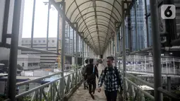 Sejumlah warga melintas di jembatan penyeberangan orang (JPO) dekat Unika Atma Jaya, Jakarta, Rabu (13/11/2019). JPO dekat Unika Atma Jaya dan Hotel Le Meridien di Jalan Jenderal Sudirman akan dicopot karena hanya berhubungan dengan trotoar yang merupakan ruang terbuka. (Liputan6.com/Faizal Fanani)