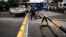 Petugas Dinas Perhubungan DKI Jakarta menurunkan beton barrier saat penutupan akses jalan menuju kawasan Kota Tua, Jumat (18/12/2020). Pemprov DKI membatasi moda transportasi melintasi kawasan wisata Kota Tua seiring penerapan kawasan rendah emisi atau Low Emission Zone. (Liputan6.com/Johan Tallo)