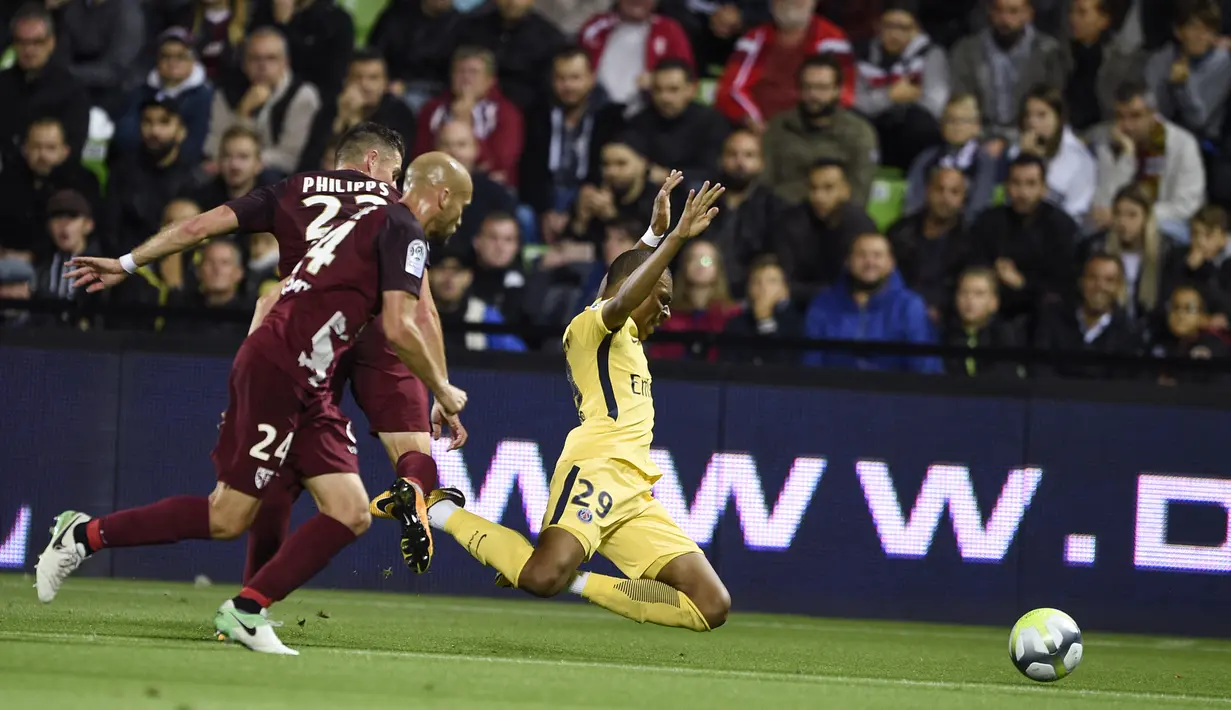 Penyerang PSG, Kylian Mbappe saat dilanggar pemain Metz pada laga lanjutan Ligue 1 di stadion Longeville-les-Metz, Prancis (8/9). PSG memboyong Mbappe dari Monaco dengan opsi pembelian 180 juta Euro atau Rp 2,85 Triliun. (AFP Photo/Patrick Hertzog)