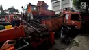 Petugas melakukan pengecekan bangkai armada truk sampah di Kantor Suku Dinas Lingkungan Hidup, Jakarta Barat, Selasa (27/3). Sebanyak 30 armada truk sampah diparkir dengan cara ditumpuk. (Liputan6.com/JohanTallo)