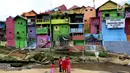 Suasana kampung warna-warni di Kelurahan Kesatrian, Kota Malang, Minggu (5/11). Ratusan rumah yang berdiri di bantaran Sungai Brantas di cat gambar warna-warni. (Liputan6.com/Fery Pradolo)