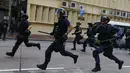 Polisi anti huru-hara saat berusaha membubarkan aksi protes yang berujung bentrok di Mongkok, Hong Kong, Selasa (9/2). Bentrokan dimulai ketika pemerintah daerah mencoba untuk menertibkan PKL yang beroperasi. (REUTERS / Bobby Yip)