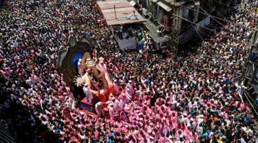 Umat hindu India mengarak patung dewa Ganesha menuju Laut Arab saat Ganesha Chaturthi di Mumbai, India, Selasa (5/9). Dalam festival ini, seluruh umat hindu India memperingati hari lahir Dewa Ganesha. (Mahesh Kumar A/AP Photo)