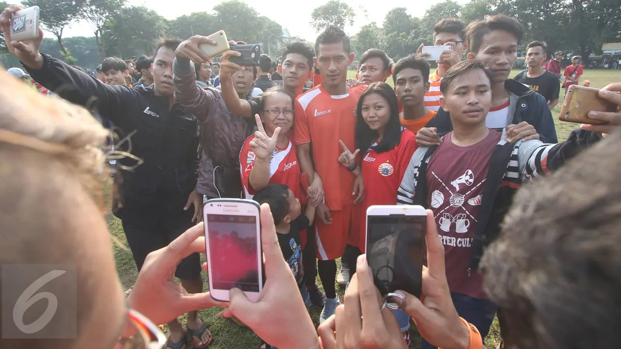 Jakmania berfoto bersama pemain Persija Jakarta seusai sesi latihan di Lapangan Banteng, Jakarta, Selasa (11/4/2017). Persija menjamu Barito Putera pada lanjutan Liga 1, Sabtu (22/4/2017). 