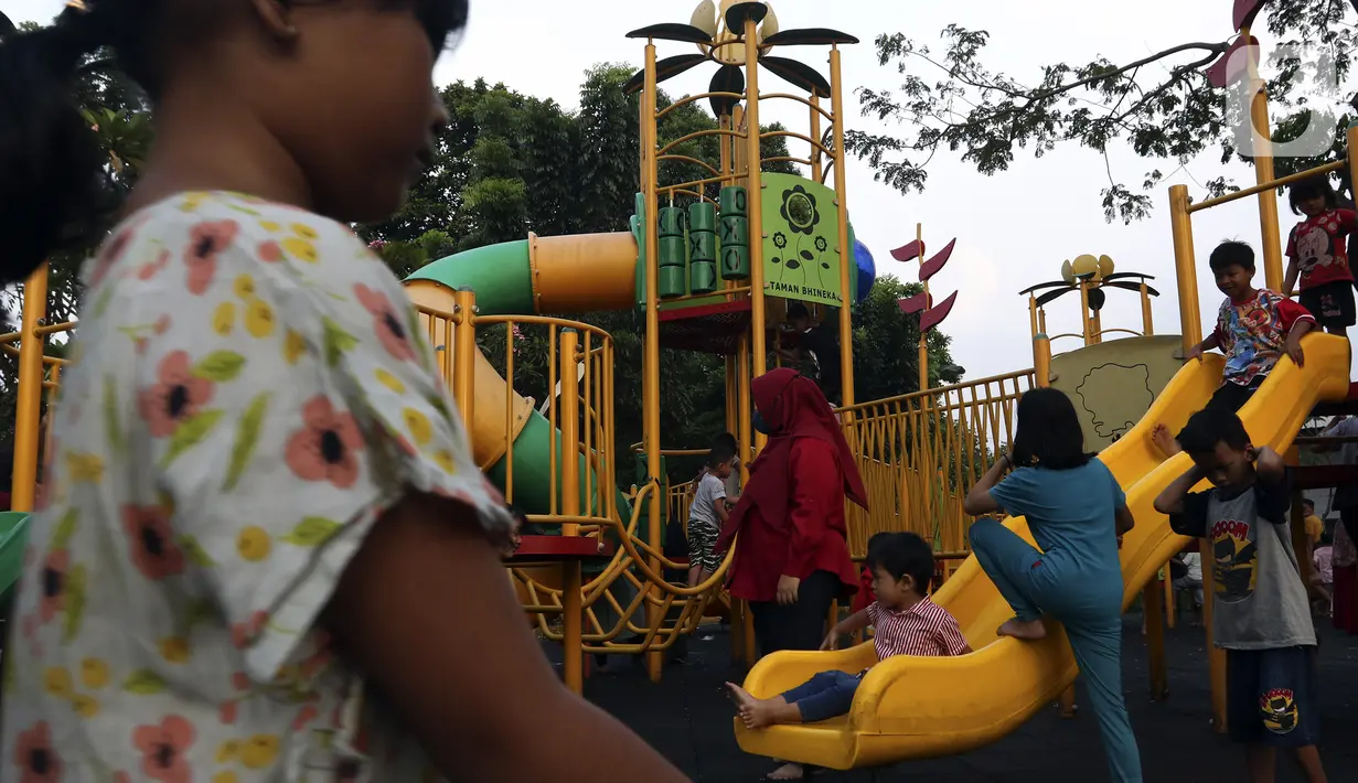 Anak-anak didampingi orangtua bermain di RPTRA Bhineka Jakarta Selatan, Sabtu (30/7/2022). Selain menjadi alternatif mengisi libur bersama keluraga, taman juga menjadi ruang bagi warga untuk berinteraksi sosial sekaligus mengeduksi anak untuk bermain bersama teman-teman dengan wahana yang tersedia. (Liputan6.com/Johan Tallo)