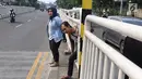 Warga menyeberang memanfaatkan pagar pembatas jalan di kawasan Pasar Minggu, Jakarta, Kamis (5/4). Kondisi Jembatan Penyeberangan Orang (JPO) yang tak kunjung diperbaiki membuat warga menyeberang lewat celah pagar pembatas (Liputan6.com/Immanuel Antonius)