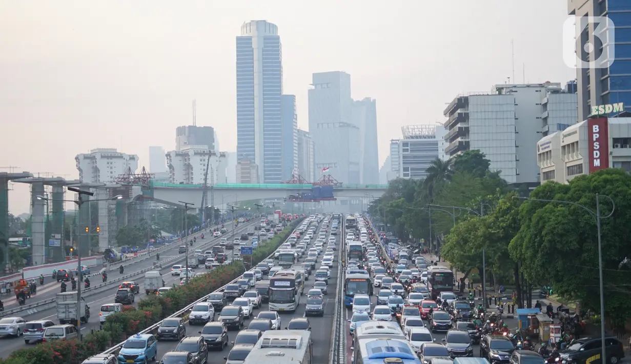 Kendaraan melintas berlatar pembangunan bentangan beton lintasan LRT di Jalan Gatot Subroto Jakarta, Kamis (7/11/2019). Menurut data terakhir Ditjen Perkeretaapian Kemenhub pada awal November 2019, pembangunan prasarana LRT Jabodebek sudah mencapai 66,79 persen. (Liputan6.com/Immanuel Antonius)