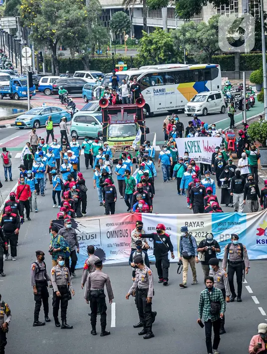 Buruh dari KSPI melakukan demonstrasi di kawasan Patung Kuda, Jakarta, Senin (12/4/2021). Buruh menutut pembayaran THR 2021 secara penuh, meminta MK membatalkan Omnibus Law, pemberlakuan UMSK, dan mendesak Kejaksaan Agung mengusut dugaan korupsi BPJS Ketenagakerjaan. (Liputan6.com/Faizal Fanani)