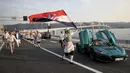 Seorang pria mengibarkan bendera Kroasia di sebelah mobil listrik 'Nevera' yang diparkir dekat Jembatan Peljesac yang baru dibangun di Komarna, Kroasia selatan, 26 Juli 2022. Kroasia menandai pembukaan kunci dan jembatan yang telah lama ditunggu-tunggu yang menghubungkan dua bagian dari garis pantai Laut Adriatik negara itu dengan melewati sebagian kecil wilayah Bosnia. (AP Photo)
