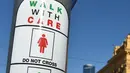Petunjuk sinyal lalu lintas untuk pejalan kaki yang baru ditampilkan pada tiang dekat Stasiun Flinders Street pada Hari Perempuan Internasional di Melbourne, Australia, Rabu (8/3). (AFP Photo / Paul Crock)