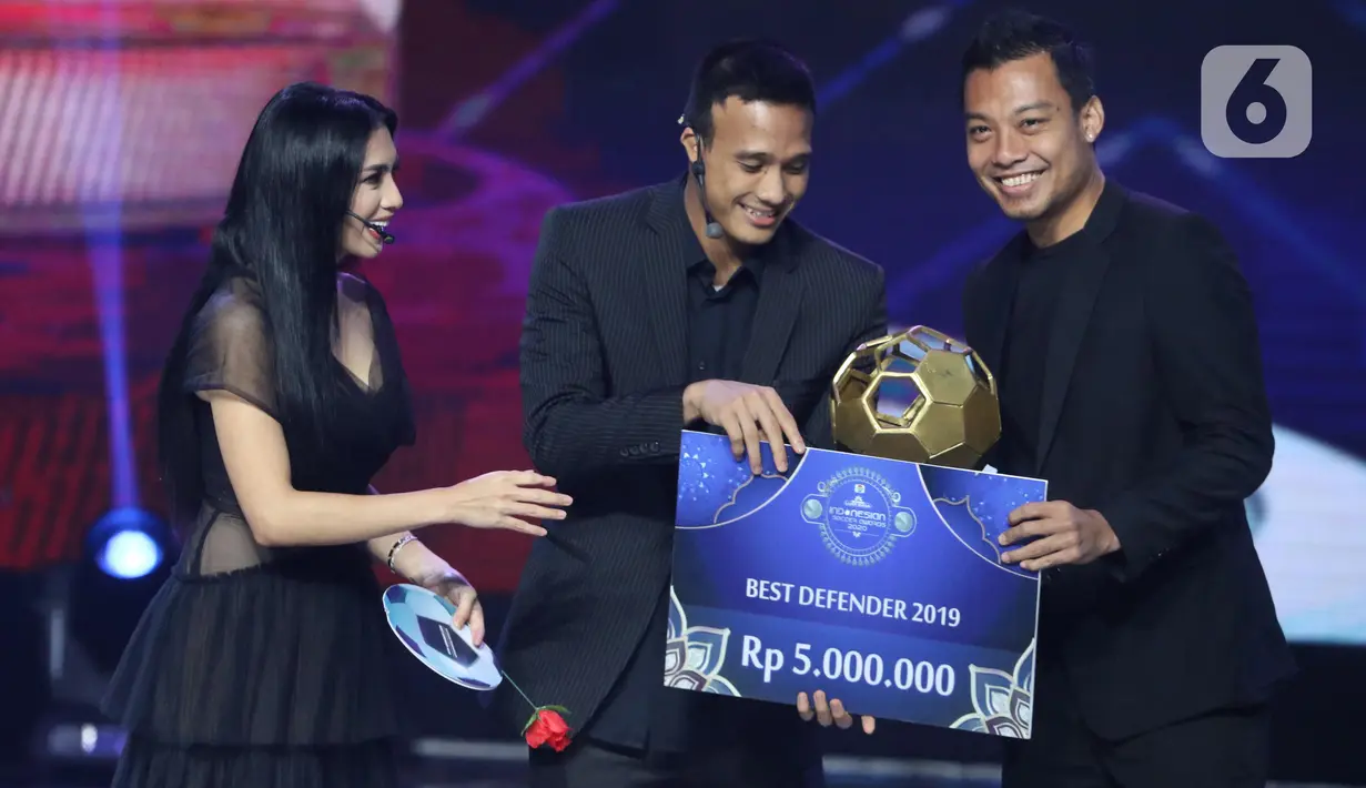 Pemain belakang Arema FC, Hamka Hamzah (kanan) menerima trofi Best Defender 2019 saat Indonesian Soccer Award 2019 di Studio 6 Indosiar, Jakarta, Jumat (10/1/2020). 16 penghargaan diberikan pada acara ini. (Liputan6.com/Helmi Fithriansyah)