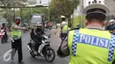 Petugas polisi saat memberhentikan pengendara motor di kawasan Cempaka Putih, Jakarta, Senin (26/10/2015). Operasi Zebra 2015 berlangsung hingga 4 November 2015 bertujuan untuk menekan pelanggaran lalulintas. (Liputan6.Com/Angga Yuniar)