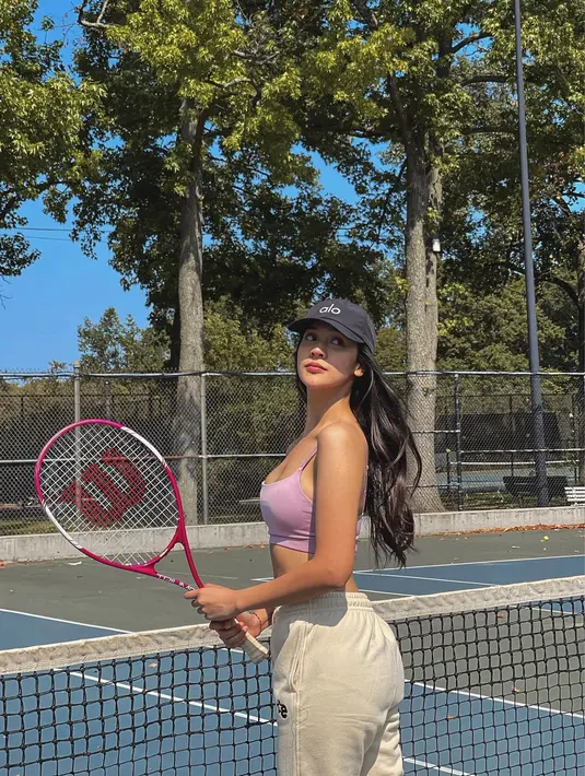Masih ketika main tenis, Anya terlihat cantik memadukan crop tank top pink dengan track pants krem dan topi hitam. @anyageraldine.