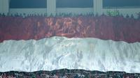 Suporter Indonesia membentangkan bendera raksasa saat laga Timnas Indonesia U-23 melawan Bahrain pada laga PSSI Anniversary Cu 2018 di Stadion Pakansari, Bogor, (26/4/2018). Bahrain unggul sementara 1-0. (Bola.com/Nick Hanoatubun)