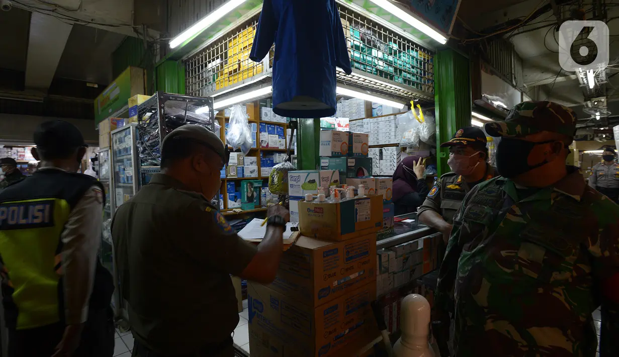 Petugas gabungan melakukan razia pertokoan dan tempat makan di Pasar Pramuka, Jakarta, Kamis (24/9/2020). Upaya mencegah penularan virus corona terus dilakukan dengan merazia penggunaan masker dan tempat usaha makan yang masih melayani makan di tempat. (merdeka.com/Imam Buhori)