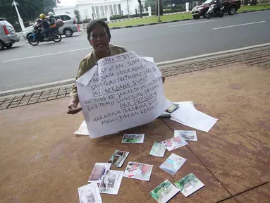 Nelly Hutabarat, guru asal Deli Serdang, Sumatera Utara, melakukan aksi diam di depan Istana Negara, Jakarta, Rabu (13/7). Nelly menuntut keadilan atas penutupan SDN 10-61-59 dan pembongkaran rumah dinasnya pada 2011 silam (Liputan6.com/Immanuel Antonius)