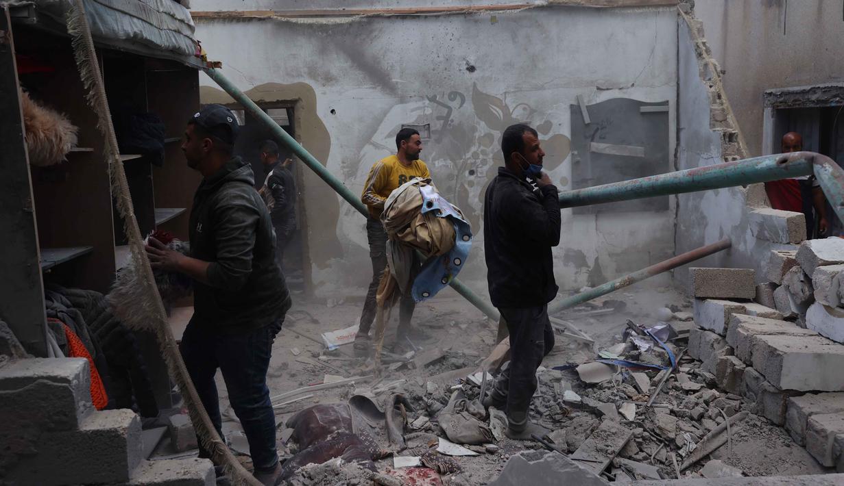 Warga Palestina yang mengungsi memeriksa kerusakan setelah sebuah rumah menjadi sasaran serangan Israel di kamp pengungsi Maghazi, Jalur Gaza Tengah pada Kamis 21 Mei 2026. (Eyad Baba/AFP)