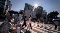 Jepang menjadi salah satu negara yang mengalami gelombang panas ekstrem, bahkan suhu mencapai 41,2 derajat celcius di Hyogo, 30 Juli 2025 lalu. Tampak dalam foto, orang-orang menyeberang jalan di Tokyo pada 4 Agustus 2025. (Kazuhiro NOGI/AFP)