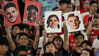 Para penggemar Arsenal menyemangati tim mereka dalam sesi latihan di Stadion Kai Tak, Hong Kong, pada 30 Juli 2025, menjelang pertandingan persahabatan melawan Tottenham Hotspur. (Peter Parks / AFP)