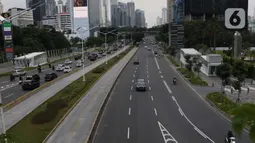 Pengendara melintasi ruas jalan Jenderal Sudirman, Jakarta, Kamis (26/3/2020). Sejak pemerintah melakukan himbauan melakukan seluruh aktivitas dari dalam rumah akibat merebaknya virus corona Covid-19, ruas-ruas jalan Ibu Kota terlihat lengang. (Liputan6.com/Helmi Fithriansyah)