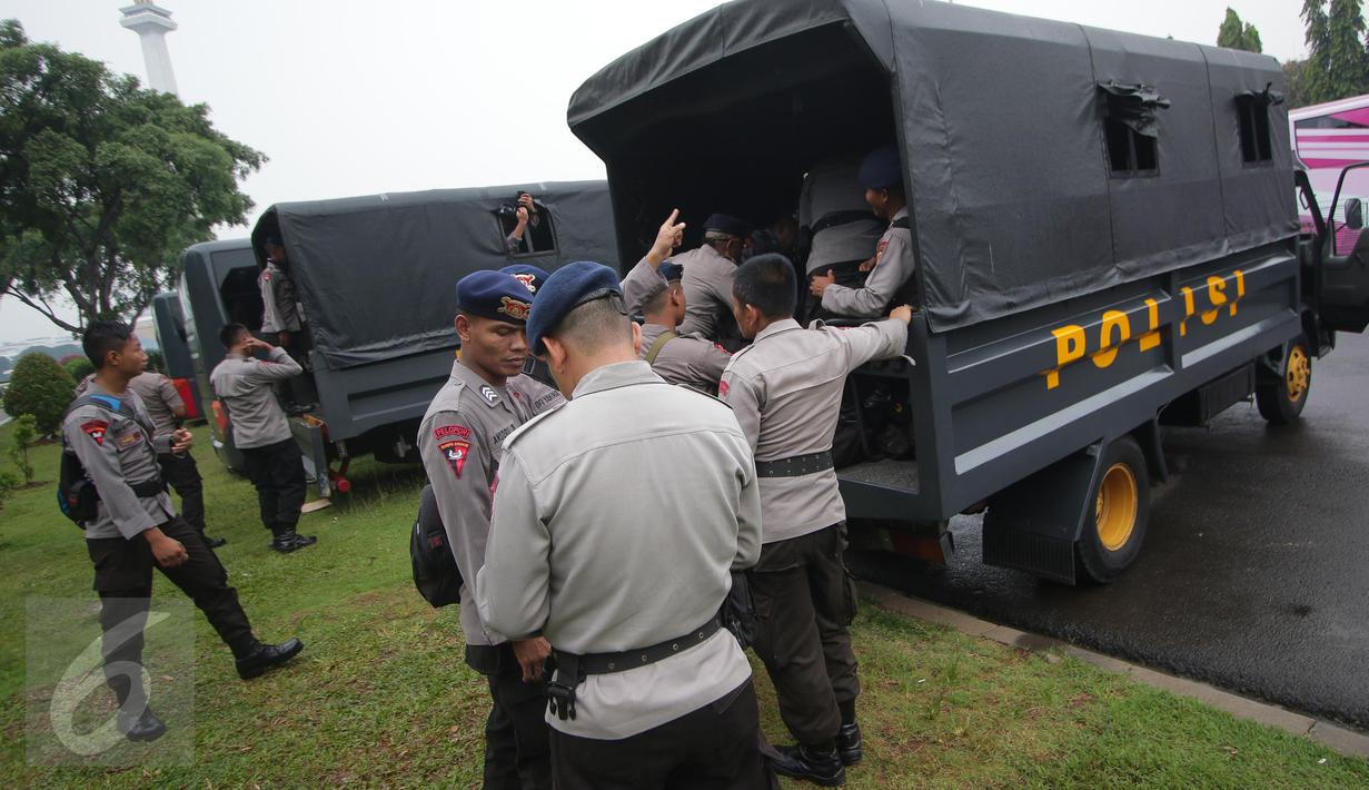 Petugas kepolisian menaiki truk pengangkut saat melakukan pengamanan di kawasan Monas, Jakarta, Selasa (18/4). Polda Metro Jaya dan Kodam Jaya mengerahkan 64.523 personel gabungan untuk mengawal Pilkada DKI 2017 putaran kedua. (Liputan6.com/Faizal Fanani)