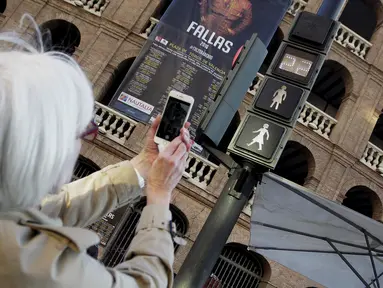 Seorang wanita mengabadikan lampu lalu lintas pejalan kaki yang bergambar sosok perempuan saat Peringatan Hari Perempuan Internasional di Valencia, Spanyol, Selasa (8/3/2016). (REUTERS/Heino Kalis)