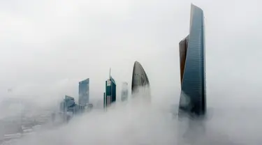 Foto udara ini memperlihatkan gedung-gedung tinggi saat pagi berkabut di Kota Kuwait pada Selasa (14/3/2023). Kemunculan kabut memperlihatkan pemandangan indah, dimana kota Kuwait terlihat seperti negeri di atas awan. (Photo by Yasser Al-Zayyat / AFP)