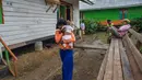 Pengungsi wanita menggendong anaknya di kompleks penampungan sementara Blang Adoe, Aceh Utara, Aceh, Rabu (27/4). Tersisa 300 orang pengungsi Rohingya di empat penampungan kabupaten/kota Pantai Utara dan Timur Aceh. (Chaideer Mahyuddin / AFP)